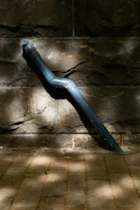 Rainwater flows through a residential gutter and downspout onto a splash block away from the foundation.